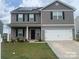 Two-story house with gray siding, solar panels, and a white garage door at 1112 Culver Spring Way, Charlotte, NC 28215