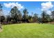Spacious backyard with a lush lawn, black fence, and a playset in the back for fun at 11317 Trailside Nw Rd, Huntersville, NC 28078