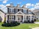 Two-story house featuring gray siding, white columns, and manicured lawn at 11317 Trailside Nw Rd, Huntersville, NC 28078