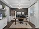 Home office with built-in shelving, large desk, and hardwood floors at 11317 Trailside Nw Rd, Huntersville, NC 28078