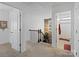 Upstairs hallway with carpet, doors to bedrooms, and a staircase at 11317 Trailside Nw Rd, Huntersville, NC 28078