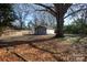 Detached garage with wooden doors in a tree-filled yard at 1138 Norland Rd, Charlotte, NC 28205