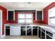 Kitchen with red walls, black cabinets, and a double sink at 1138 Norland Rd, Charlotte, NC 28205