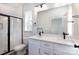 This bathroom has double sinks, dark hardware, shower with glass door, and a bright window at 116 Durham Rd, Stanley, NC 28164