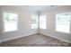 Bright bedroom with three windows and wood-look flooring at 116 Durham Rd, Stanley, NC 28164