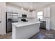 Modern kitchen featuring white cabinets, stainless steel appliances, and a large island with quartz countertops at 116 Durham Rd, Stanley, NC 28164