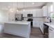 Bright kitchen with stainless steel appliances, white cabinets, an island and quartz countertops at 116 Durham Rd, Stanley, NC 28164