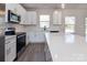 Modern kitchen featuring white cabinets, stainless steel appliances, and an island with quartz countertops at 116 Durham Rd, Stanley, NC 28164