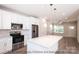 White kitchen with stainless steel appliances and an island with seating at 116 Durham Rd, Stanley, NC 28164