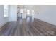 Open-concept living area with wood-look floors flowing into a modern kitchen with white cabinets at 116 Durham Rd, Stanley, NC 28164