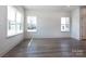 Light-filled living room with wood-look floors, large windows offering ample sunlight, and a white interior at 116 Durham Rd, Stanley, NC 28164