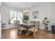 Dining room with light-colored table and chairs, hardwood floors, and large windows at 122 Still Creek Dr, Mooresville, NC 28115