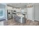 Well-lit kitchen boasting white cabinetry, stainless steel appliances, and a stylish island with seating at 1244 Scotch Meadows Loop, Monroe, NC 28110