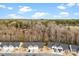 Aerial view of similar single-Gathering homes in a community with extensive woodlands in the background at 1355 Amberlight Cir, Salisbury, NC 28144