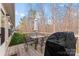 View of outdoor deck featuring a grill, table and chairs, and wooded backdrop at 1355 Amberlight Cir, Salisbury, NC 28144