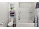 Clean bathroom featuring a shower-tub combo, a toilet, and decorative shelving for storage at 1355 Amberlight Cir, Salisbury, NC 28144