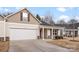 Charming home with a two-car garage, covered entryway, and neutral beige and stone exterior at 1355 Amberlight Cir, Salisbury, NC 28144