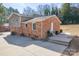 Back exterior of a split-level home with brick and siding, a spacious driveway and a patio at 1401 Southwest Blvd, Newton, NC 28658