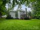 Spacious backyard with a well-maintained lawn, mature trees, and a deck with pergola off the house at 172 Foxtail Dr, Mooresville, NC 28117