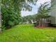 Large backyard featuring a well-manicured lawn, mature trees, and a deck with a pergola at 172 Foxtail Dr, Mooresville, NC 28117