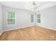 Spacious bedroom with natural light, wood-look flooring, a ceiling fan, and three windows at 172 Foxtail Dr, Mooresville, NC 28117