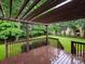 Back deck overlooking backyard with mature trees, wooden pergola, and a wood privacy fence at 172 Foxtail Dr, Mooresville, NC 28117