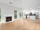 Bright living room with fireplace and kitchen view, featuring hardwood floors and large windows at 172 Foxtail Dr, Mooresville, NC 28117