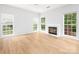 Bright living room boasts hardwood floors, and fireplace with multiple windows for natural light at 172 Foxtail Dr, Mooresville, NC 28117