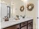 Elegant bathroom with dual sinks, marble countertop, dark wood cabinets, and decorative accents at 200 Staffordshire Dr, Statesville, NC 28625