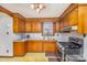 Retro kitchen with wood cabinets, gas range and microwave at 202 W Main St, Cherryville, NC 28021