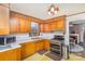 Retro kitchen with wood cabinets, gas range and microwave at 202 W Main St, Cherryville, NC 28021