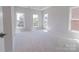 Bedroom with large windows that offer a view of mature trees, carpeted floor, and neutral paint at 216 Gilead Rd, Huntersville, NC 28078