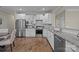 Bright open kitchen with white cabinetry, granite counters, stainless steel appliances, and hardwood floors at 250 Cherry Tree Dr, Fort Mill, SC 29715