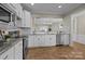 Bright open kitchen with white cabinetry, stainless steel appliances, hardwood floors, and a breakfast bar at 250 Cherry Tree Dr, Fort Mill, SC 29715