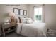 Cozy bedroom featuring a queen bed, decorative pillows, and a nightstand with lamp and artwork at 2533 Ellen Ave # 1016B, Charlotte, NC 28208