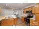 Kitchen featuring stainless steel appliances, wood cabinets, and an adjacent dining area at 2604 Cochrane Dr, Charlotte, NC 28269