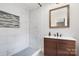 Bathroom with a vanity featuring a wood cabinet and modern faucet, plus white marble style tiled shower at 2624 Ashley Rd, Charlotte, NC 28208