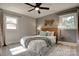 Cozy bedroom features a stylish ceiling fan, wood headboard, and warm natural light from two sunny windows at 2624 Ashley Rd, Charlotte, NC 28208