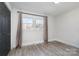 Bedroom with lots of natural light, neutral walls, wood-look flooring and a closet with gray doors at 2624 Ashley Rd, Charlotte, NC 28208