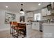 Bright kitchen with white cabinets, stainless steel appliances, an island with bar stools, and wood accents at 2624 Ashley Rd, Charlotte, NC 28208