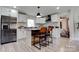 Modern kitchen featuring white cabinets, stainless steel appliances, an island with seating, and stylish backsplash at 2624 Ashley Rd, Charlotte, NC 28208