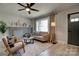 Bright living room with a stone fireplace, large window, comfortable seating, and light wood flooring at 2624 Ashley Rd, Charlotte, NC 28208