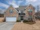 Two-story brick home with a white garage door and landscaping at 2748 Smethwick Ln, Gastonia, NC 28056