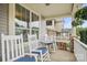 Front porch with rocking chairs, a small table, and hanging flower baskets at 3205 Helmsley Ct, Concord, NC 28027