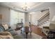 Spacious living room with hardwood floors, a gray sofa and a view to the kitchen at 3205 Helmsley Ct, Concord, NC 28027