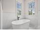 Bright bathroom showcasing a freestanding tub, marble tile, and stylish windows at 357 Magnolia St, Davidson, NC 28036