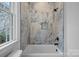 Cozy bathroom featuring a tub/shower combo and tiled walls at 357 Magnolia St, Davidson, NC 28036