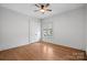 Bright, empty bedroom featuring hardwood floors, ceiling fan, window, and a closet at 357 Magnolia St, Davidson, NC 28036