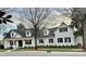 Charming two-story white brick home with a black roof, black shutters and a inviting front porch at 357 Magnolia St, Davidson, NC 28036