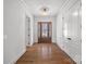 Bright foyer with hardwood floors, white walls, an elegant chandelier, and a decorative wood front door at 357 Magnolia St, Davidson, NC 28036